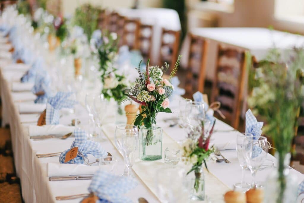 Hochzeit-Blumendekoration auf einem langen Tisch