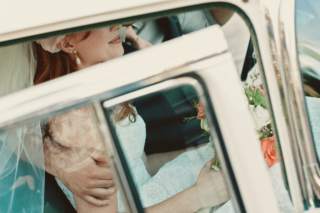 Braut mit vintage Brautstrauß in Hochzeitswagen